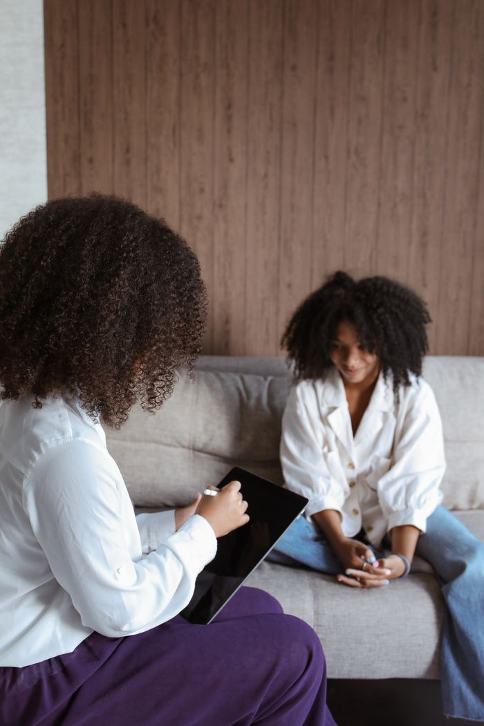 Two women in a psychotherapy session discussing mental health issues.